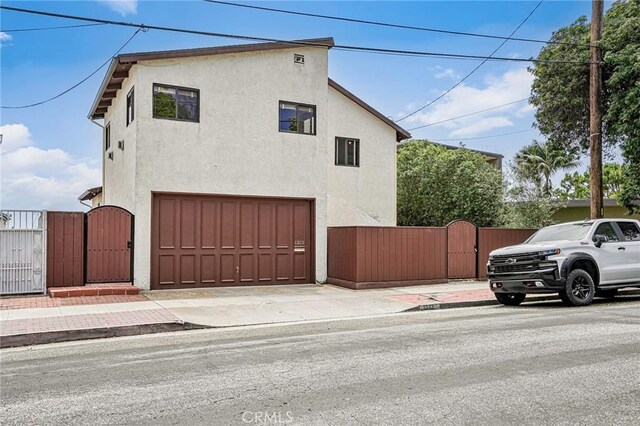 1323 Silvius Ave, San Pedro, CA 90731 - view of home's exterior with a gate, a garage, stucco siding, and concrete driveway