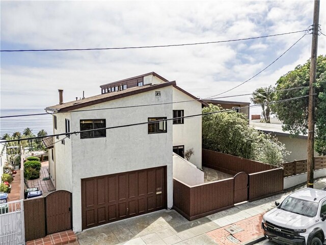 1323 Silvius Ave, San Pedro, CA 90731 - view of front of house featuring a gate, a garage, stucco siding, and a water view