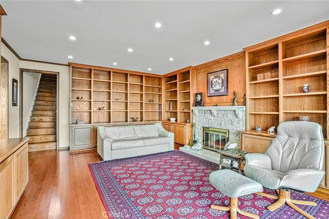1323 Silvius Ave, San Pedro, CA 90731 - sitting room featuring built in shelves, recessed lighting, a stone fireplace, ornamental molding, and wood finished floors