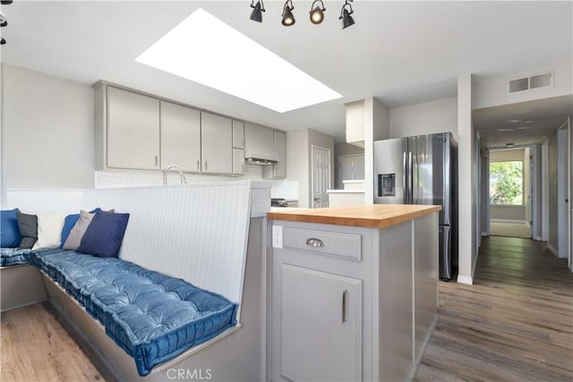 14220 El Monte Rd, Atascadero, CA 93422 - kitchen featuring stainless steel fridge, butcher block counters, dark wood-style floors, open floor plan, and a skylight