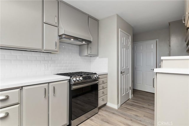 14220 El Monte Rd, Atascadero, CA 93422 - kitchen with stainless steel gas range, light wood-style floors, light countertops, and tasteful backsplash