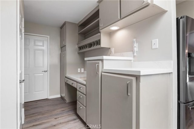 14220 El Monte Rd, Atascadero, CA 93422 - kitchen featuring stainless steel fridge, gray cabinetry, open shelves, light wood-type flooring, and light countertops