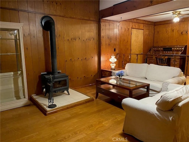 1004 Coldwater Dr, Frazier Park, CA 93225 - living area with wooden walls, a wood stove, ceiling fan, wood finished floors, and beamed ceiling