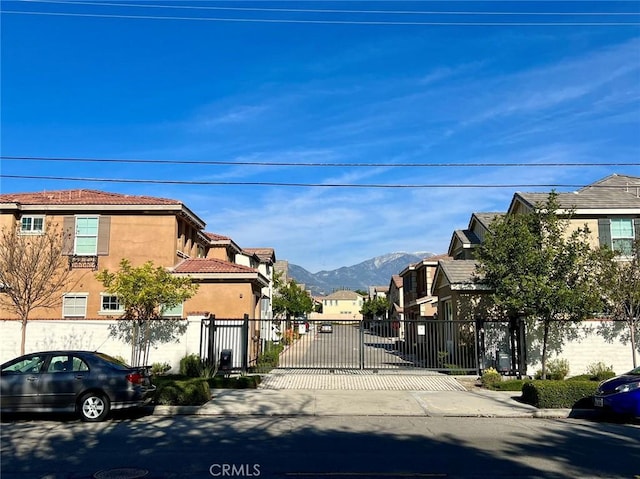 1504 Granada Rd, Upland, CA 91786 - view of concrete street featuring a gate, a residential view, a mountain view, and curbs