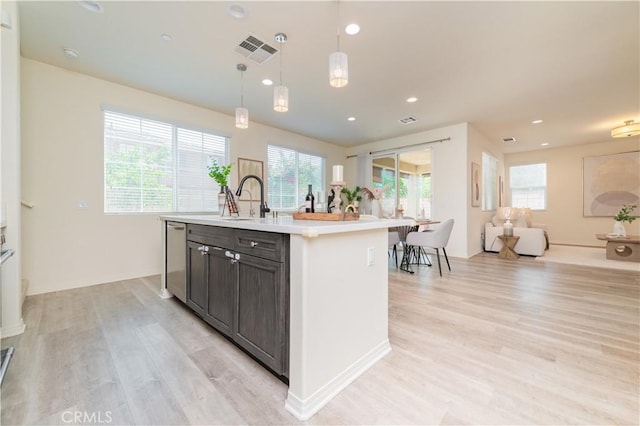 1504 Granada Rd, Upland, CA 91786 - kitchen with stainless steel dishwasher, light wood finished floors, light countertops, a kitchen island with sink, and recessed lighting