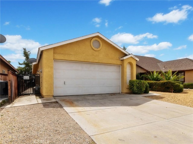 16873 Silica Dr, Victorville, CA 92395 - view of front facade with stucco siding, an attached garage, driveway, and a gate