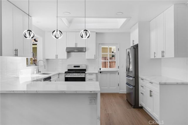 2610 Via Pacheco, Palos Verdes Estates, CA 90274 - kitchen with appliances with stainless steel finishes, under cabinet range hood, wood finished floors, white cabinets, and decorative backsplash