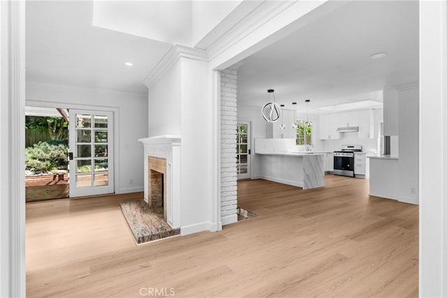 2610 Via Pacheco, Palos Verdes Estates, CA 90274 - unfurnished living room with ornamental molding, light wood-style flooring, a fireplace with raised hearth, and recessed lighting