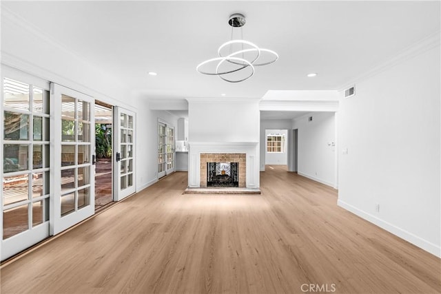 2610 Via Pacheco, Palos Verdes Estates, CA 90274 - unfurnished living room with healthy amount of natural light, light wood-style flooring, crown molding, a chandelier, and a brick fireplace