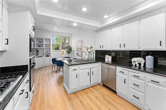 532 Riviera Ct, Fullerton, CA 92835 - kitchen featuring appliances with stainless steel finishes, crown molding, light wood finished floors, a peninsula, and a tray ceiling