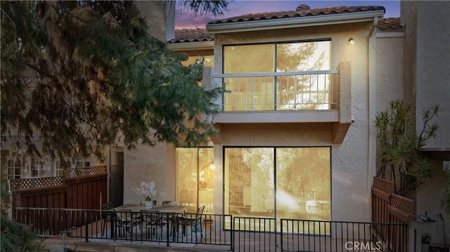 532 Riviera Ct, Fullerton, CA 92835 - back of property at dusk with stucco siding, a tiled roof, and a balcony