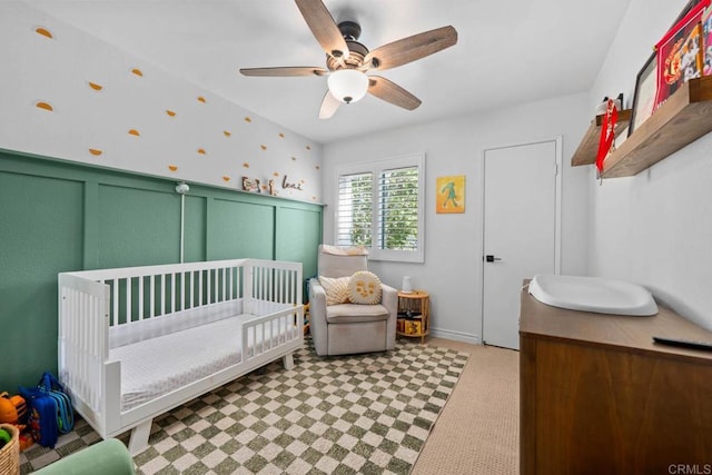13323 Rancho Penasquitos Blvd Unit D206, San Diego, CA 92129 - bedroom with a nursery area, a ceiling fan, and a wainscoted wall