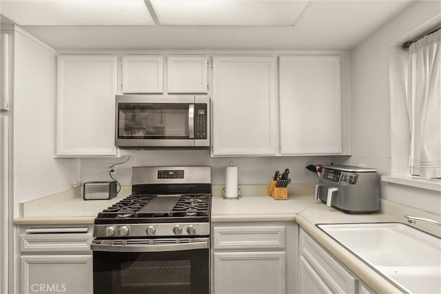 9765 Alburtis Ave Unit 143, Santa Fe Springs, CA 90670 - kitchen featuring stainless steel appliances, white cabinetry, and light countertops