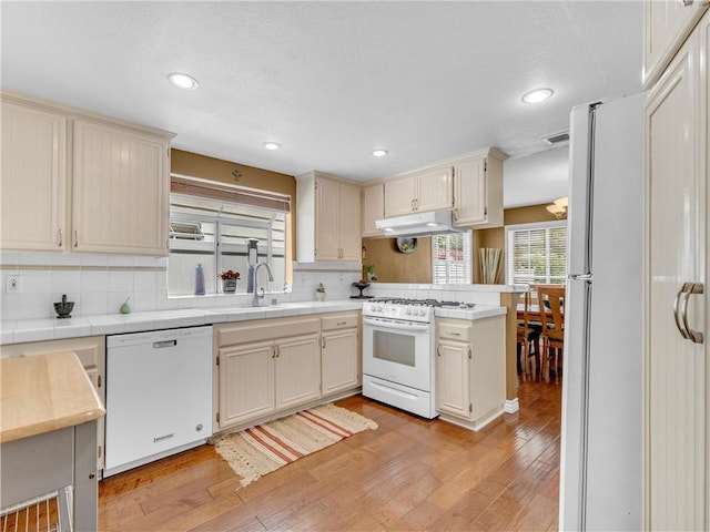 2756 Lemon Dr, Simi Valley, CA 93063 - kitchen with white appliances, under cabinet range hood, decorative backsplash, light wood finished floors, and recessed lighting