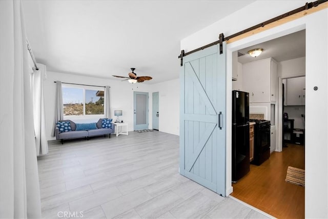 74697 Baseline Rd Unit 29, Palms, CA 92277 - kitchen with a barn door, black appliances, a ceiling fan, and light wood-style flooring