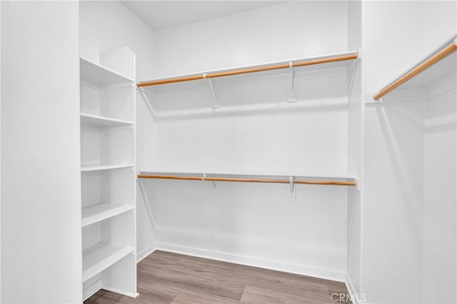 208 Harringay, Irvine, CA 92618 - walk in closet featuring wood finished floors