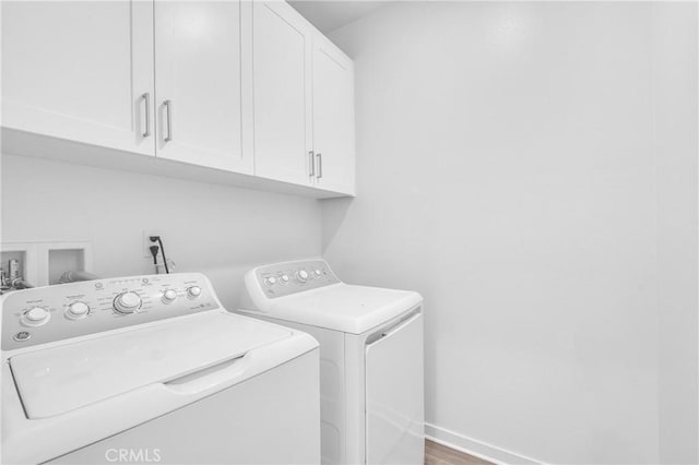208 Harringay, Irvine, CA 92618 - laundry area with cabinet space, washer and dryer, and wood finished floors