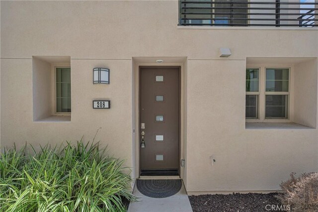 208 Harringay, Irvine, CA 92618 - doorway to property featuring stucco siding