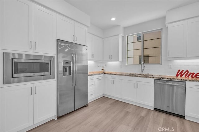 208 Harringay, Irvine, CA 92618 - kitchen featuring stainless steel appliances, light stone countertops, white cabinets, tasteful backsplash, and recessed lighting