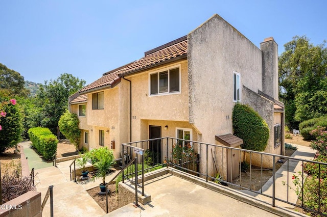 5036 Echo St Unit 37, Los Angeles, CA 90042 - exterior space featuring a tile roof, stucco siding, a chimney, and a patio