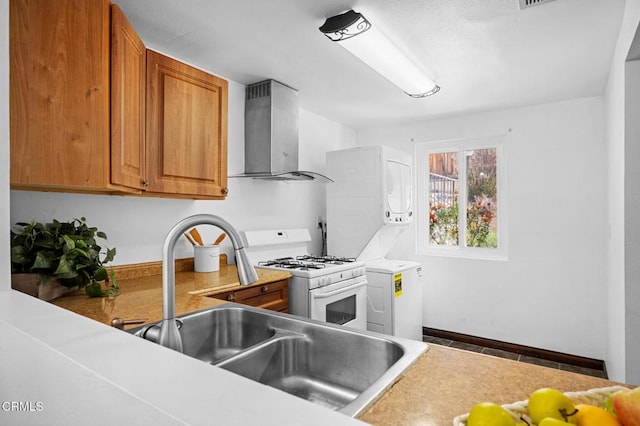 5036 Echo St Unit 37, Los Angeles, CA 90042 - kitchen with wall chimney range hood, white range with gas stovetop, brown cabinetry, and light countertops