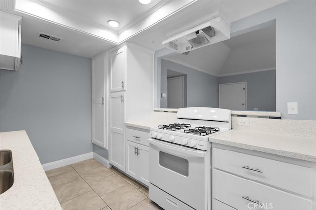 1477 Clemson Way, Riverside, CA 92507 - kitchen featuring white range with gas stovetop, ornamental molding, white cabinetry, light tile patterned flooring, and light stone countertops