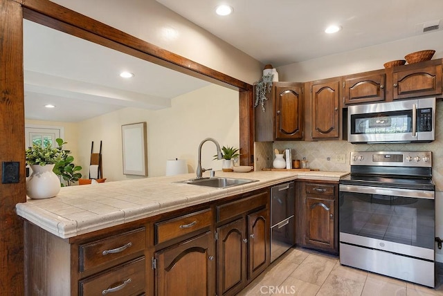 406 University Ave, Burbank, CA 91504 - kitchen with appliances with stainless steel finishes, a peninsula, tasteful backsplash, tile counters, and recessed lighting