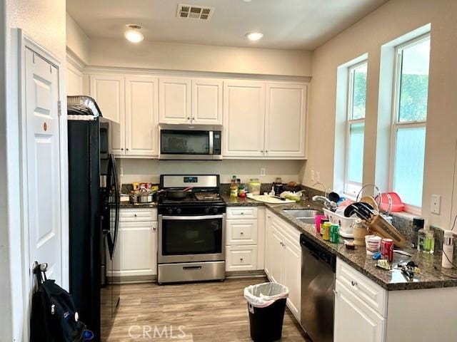 11 Lilac Ln, Compton, CA 90221 - kitchen featuring stainless steel appliances, white cabinetry, light wood-style floors, recessed lighting, and dark stone countertops