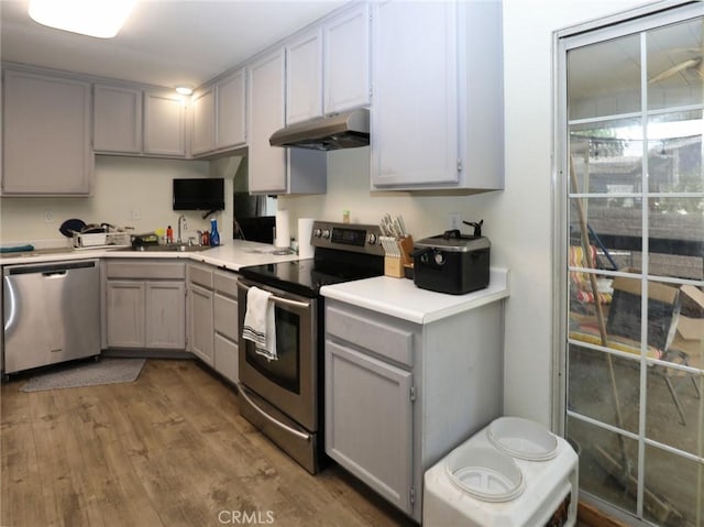 3687 Madison Dr, Clearlake, CA 95422 - kitchen featuring stainless steel appliances, under cabinet range hood, gray cabinets, and wood finished floors