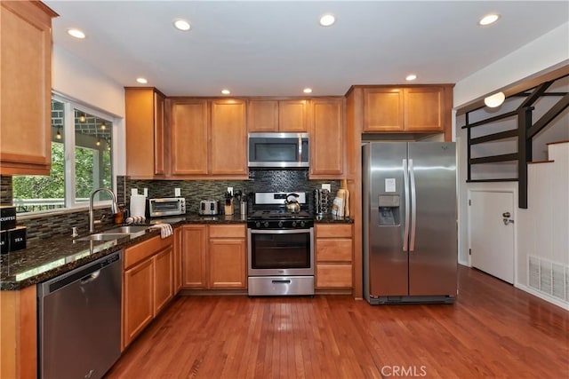 394 Emerald Dr, Lake Arrowhead, CA 92352 - kitchen with stainless steel appliances, dark wood-type flooring, tasteful backsplash, dark stone counters, and recessed lighting
