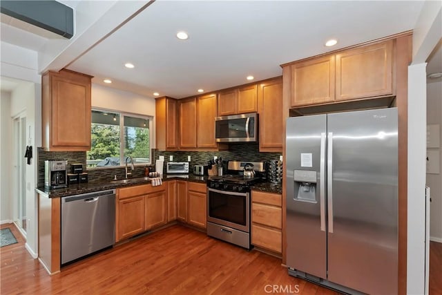 394 Emerald Dr, Lake Arrowhead, CA 92352 - kitchen with stainless steel appliances, wood finished floors, decorative backsplash, recessed lighting, and dark stone counters