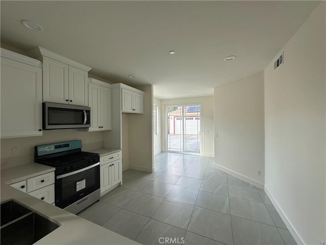 5215 Peony Ct, Riverside, CA 92506 - kitchen featuring stainless steel appliances, light countertops, white cabinets, light tile patterned flooring, and recessed lighting