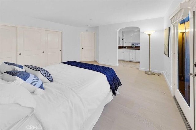 1749 Grand Ave Unit 4, Long Beach, CA 90804 - bedroom with arched walkways, a closet, ensuite bath, and light wood finished floors