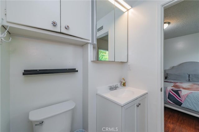 1068 Richmond Dr, Claremont, CA 91711 - ensuite bathroom featuring vanity, wood finished floors, and a textured ceiling