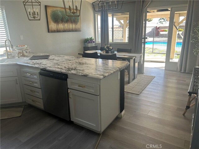 2258 El Rio St, Lancaster, CA 93535 - kitchen with stainless steel dishwasher, a chandelier, dark wood-style flooring, light stone counters, and white cabinets