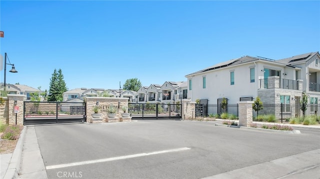 480 W Balsam Ln, Clovis, CA 93611 - view of asphalt road featuring a gate, a residential view, a gated entry, curbs, and street lighting