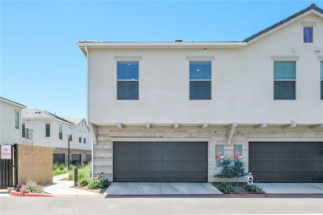 480 W Balsam Ln, Clovis, CA 93611 - view of property featuring a garage, stone siding, stucco siding, and driveway