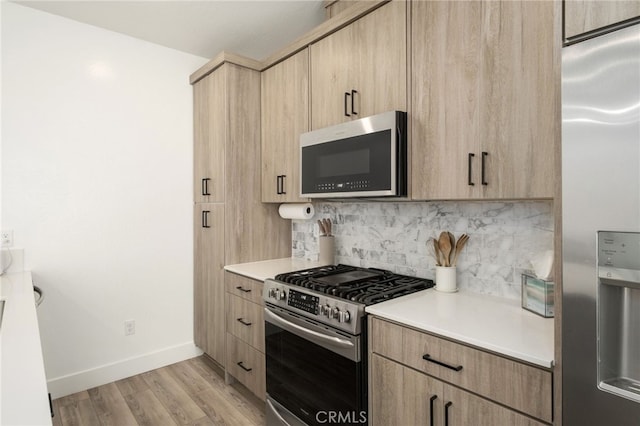 480 W Balsam Ln, Clovis, CA 93611 - kitchen with appliances with stainless steel finishes, light brown cabinetry, tasteful backsplash, light countertops, and light wood-style flooring