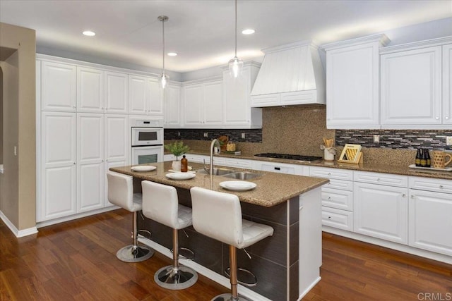 15809 Concord Rdg, San Diego, CA 92127 - kitchen featuring premium range hood, stainless steel gas cooktop, tasteful backsplash, a breakfast bar, and white cabinetry