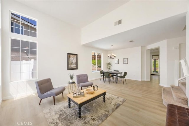 5444 Broderick Ct, Hemet, CA 92544 - living room featuring a chandelier, light wood-style flooring, healthy amount of natural light, stairs, and a high ceiling