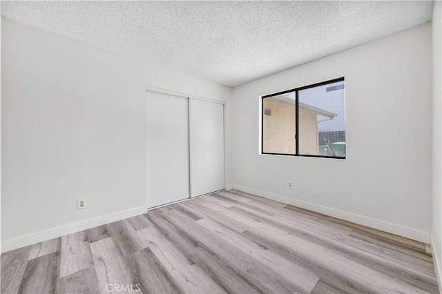 14225 Woodpark Dr, Moreno Valley, CA 92553 - unfurnished bedroom featuring wood finished floors, a closet, and a textured ceiling