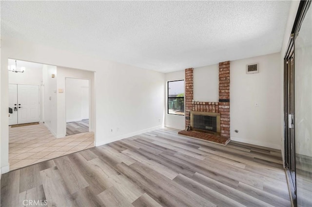 14225 Woodpark Dr, Moreno Valley, CA 92553 - unfurnished living room featuring a textured ceiling, wood finished floors, a fireplace, and a chandelier