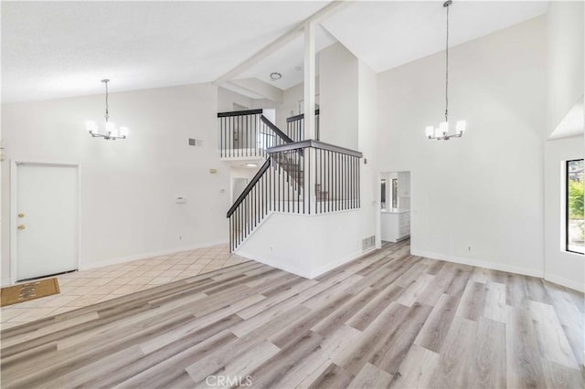 14225 Woodpark Dr, Moreno Valley, CA 92553 - unfurnished living room with a chandelier, high vaulted ceiling, wood finished floors, and stairway