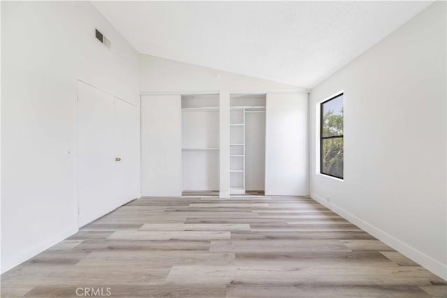 14225 Woodpark Dr, Moreno Valley, CA 92553 - unfurnished bedroom with two closets, vaulted ceiling, and light wood-type flooring