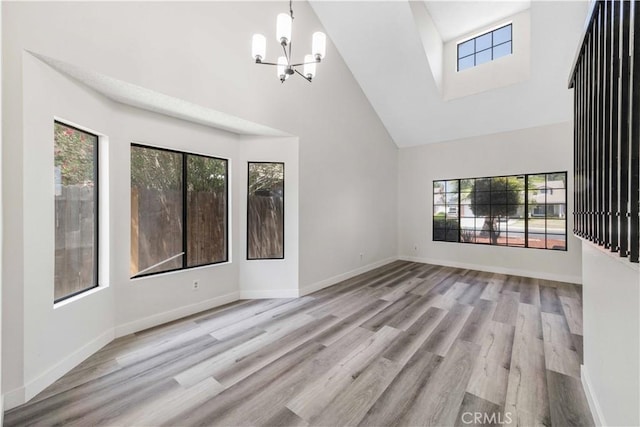 14225 Woodpark Dr, Moreno Valley, CA 92553 - unfurnished living room featuring high vaulted ceiling, healthy amount of natural light, a chandelier, and wood finished floors