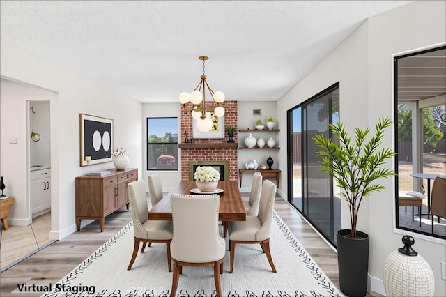 14225 Woodpark Dr, Moreno Valley, CA 92553 - dining area featuring light wood-style flooring, a chandelier, and a fireplace