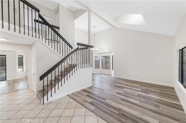 14225 Woodpark Dr, Moreno Valley, CA 92553 - stairs featuring high vaulted ceiling, a chandelier, wood finished floors, and a skylight