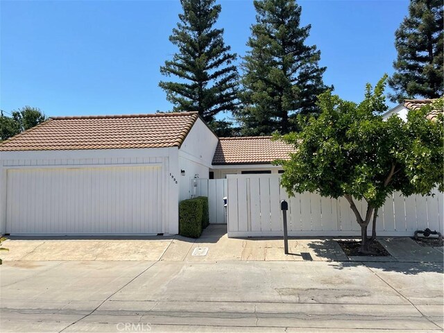 1935 W Santa Ana Ave, Fresno, CA 93705 - view of front facade with a tiled roof, a gate, a garage, and concrete driveway