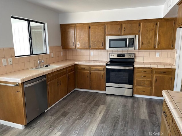 1935 W Santa Ana Ave, Fresno, CA 93705 - kitchen featuring stainless steel appliances, dark wood finished floors, and brown cabinets