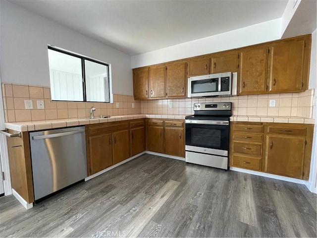 1935 W Santa Ana Ave, Fresno, CA 93705 - kitchen featuring stainless steel appliances, tile counters, and brown cabinets
